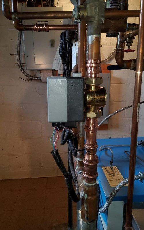 Replaced defective zone valve and damaged 1.25" copper piping section on hydronic heating system. Drained system, installed new zone valve with proper electrical connections to Honeywell control unit, fabricated and soldered copper pipe replacement with appropriate fittings and supports, refilled system, and completed full purge procedure to eliminate air from lines.