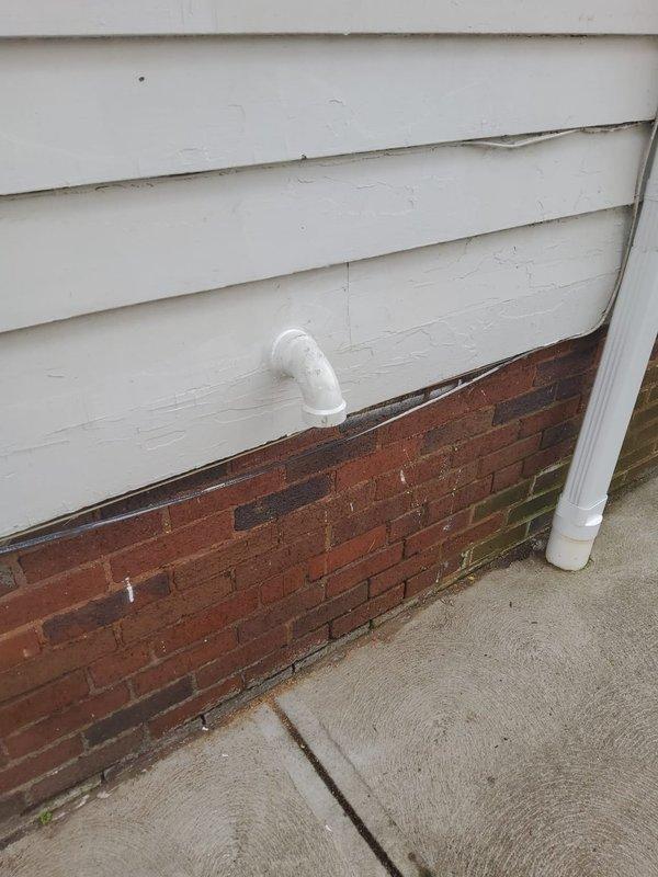 Installed power vent water heater system in commercial building basement utility area. Completed copper piping connections, integrated expansion tank, and routed PVC exhaust vent through exterior wall above brick foundation line with proper elbow configuration for horizontal termination.