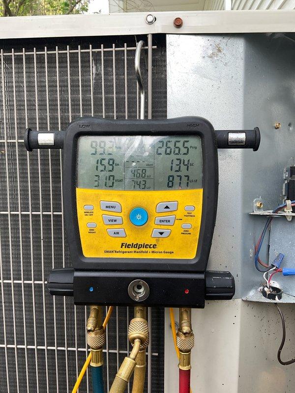 Completed comprehensive air conditioning tune-up on 10-12 year old outdoor condensing unit located on driveway side of property. Performed refrigerant system diagnostics using digital manifold gauges to verify proper operating pressures and temperatures, inspected condenser coil condition finding fins in good working order with uniform spacing, and evaluated overall system performance. Interior furnace blower assembly was accessed and inspected to ensure proper airflow throughout the cooling system.