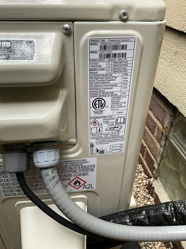 Installed 12,000 BTU one-to-one heat pump mini split system on third floor with indoor head unit mounted above window near ceiling peak. Ran approximately 50-foot line set through line hide concealment, entering below window level and routing up wall to connect to unit. Connected system to dedicated 20-amp circuit from newly installed subpanel, with outdoor condenser mounted on exterior wall and all refrigerant lines and electrical wiring properly secured and protected through white corrugated conduit.