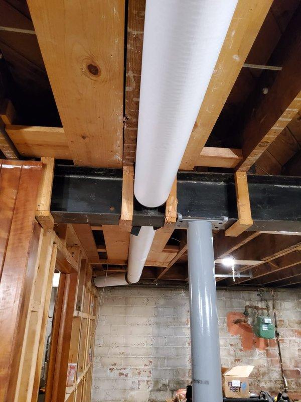 Inspected basement boiler piping system and identified exposed hot water supply and return lines requiring insulation to improve energy efficiency and prevent heat loss. Consulted with property contact regarding insulation specifications and documented current conditions of uninsulated white PVC and gray metal piping running through exposed ceiling joists above unfinished basement area. Recommended proper pipe insulation installation to meet code requirements and optimize system performance.