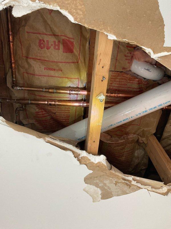 Responded to emergency plumbing repair at vacant property with freeze-damaged water lines. Cut out and replaced multiple burst ProPress fittings and split copper waterlines in wall and ceiling cavities. Opened drywall in entryway wall and ceiling to access damaged sections of plumbing system. Replaced main water shut-off valve during repair process. Pressurized system and conducted comprehensive leak testing throughout the home to verify integrity of all repairs and identify any additional compromised sections. System drained upon completion to prevent further freeze damage. Property requires additional drywall and ceiling repairs by qualified contractor to close opened access areas.