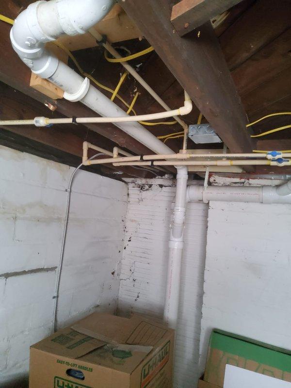 Completed comprehensive plumbing assessment of basement utility area, documenting existing plumbing infrastructure including PVC supply and drain lines, pipe routing through floor joists, and overall system condition. Photographed all accessible plumbing components, pipe connections, and support installations to provide customer with detailed visual documentation of current plumbing configuration for future reference and maintenance planning.