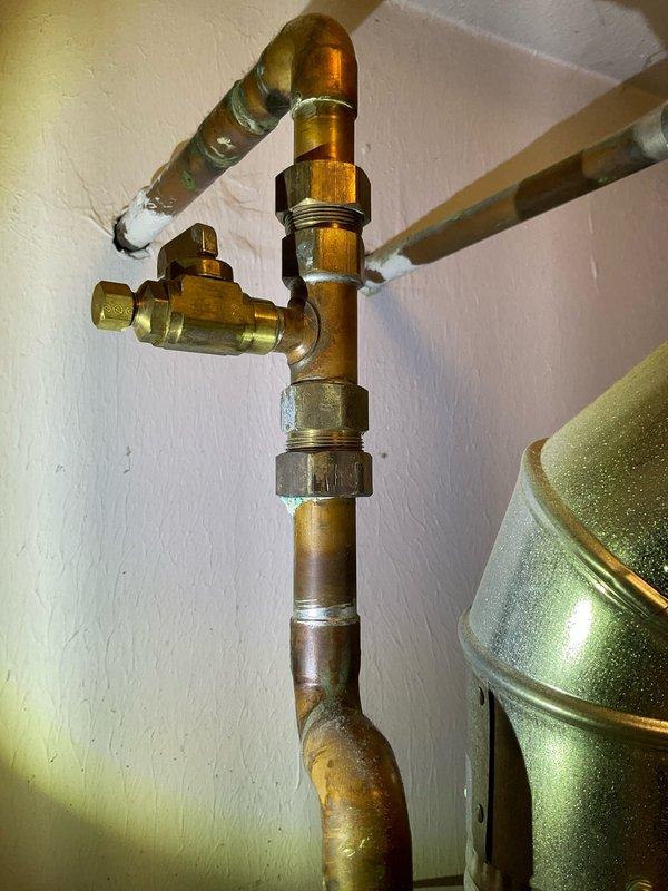 Performed flush and fill service on natural gas tanked water heater. Drained sediment buildup from tank through drain valve, flushed system with fresh water to remove mineral deposits and debris, then refilled unit to proper operating level. Inspected copper supply lines, brass shutoff valves, and connection fittings for leaks or corrosion—all found to be in functional condition with normal patina present on older piping. Provided quote for anode rod replacement to extend tank lifespan and prevent premature corrosion failure. Verified proper water flow and temperature upon completion.