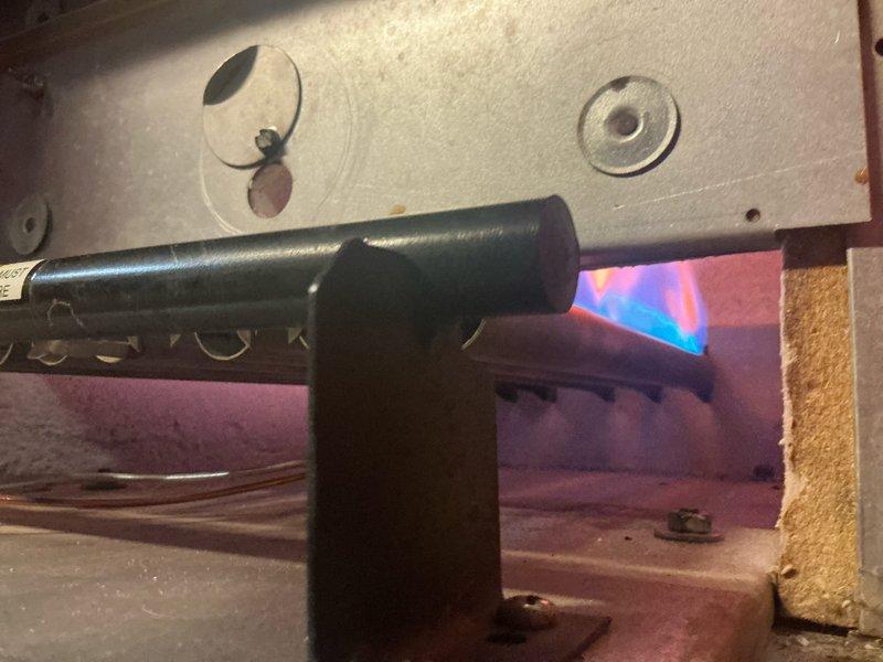 Performed comprehensive tune-up on 15-year-old boiler system, which was operating properly at time of service. Inspected gas burner assembly and combustion chamber, confirming proper flame characteristics with blue combustion pattern and adequate gas distribution through burner ports. Examined heat exchanger coils, noting dust and debris accumulation on spiral fin surfaces; cleaned heat exchanger sections to restore optimal heat transfer efficiency. Verified combustion chamber integrity, including insulation condition and panel seating. Additionally inspected radiant heating system in garage as requested, confirming proper operation of radiant heat components and distribution lines.