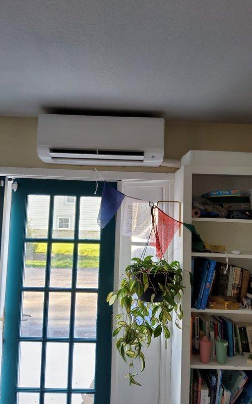 Responded to service call for 2-3 year old mini split system that was shutting off after one second of operation with blinking dotted line error code displayed on indoor unit. Upon arrival, performed diagnostic evaluation of both indoor wall-mounted evaporator unit and outdoor condenser unit. Inspected electrical connections, refrigerant lines, and communication wiring between indoor and outdoor components. Troubleshot error code indication and identified system malfunction. Tested unit operation and verified proper functionality of mini split system upon completion of service. Documented equipment condition with photographs of outdoor condenser unit mounted on exterior wall and indoor air handler installed above interior French door.