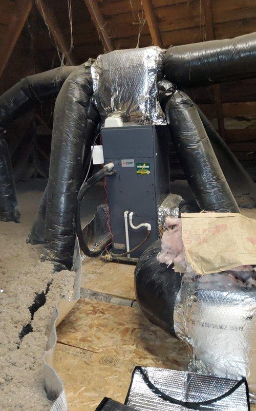 Responded to service call for air conditioning system not blowing cold air. Upon inspection, discovered severely corroded refrigerant line connections at the air handler unit located in the attic space. The compression fittings and coupling nuts exhibited heavy oxidation with greenish-brown patina, indicating prolonged moisture exposure and compromised refrigerant line integrity. Documented the corroded connections and overall system condition with photographic evidence. The deteriorated fittings pose a potential refrigerant leak risk that requires immediate attention to restore proper cooling function and system efficiency.