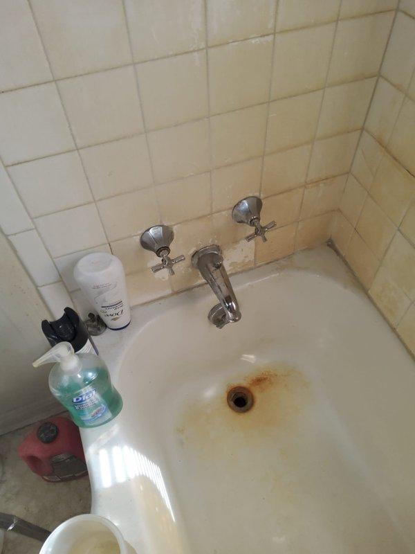 Responded to leak repair estimate request for second floor bathroom and basement. Upon inspection, identified rust staining around bathroom sink drain indicating chronic moisture exposure and potential trap leakage. Examined basement utility sink area, noting aged plumbing fixtures, corroded faucet assembly, and visible water damage on concrete surfaces. Documented conditions with photographs showing deteriorated grout lines, discolored tile surfaces, and aging plumbing connections requiring attention. Provided assessment of leak sources and recommended repairs for both locations to prevent further water damage.