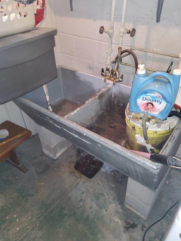 Responded to leak repair estimate request for second floor bathroom and basement. Upon inspection, identified rust staining around bathroom sink drain indicating chronic moisture exposure and potential trap leakage. Examined basement utility sink area, noting aged plumbing fixtures, corroded faucet assembly, and visible water damage on concrete surfaces. Documented conditions with photographs showing deteriorated grout lines, discolored tile surfaces, and aging plumbing connections requiring attention. Provided assessment of leak sources and recommended repairs for both locations to prevent further water damage.