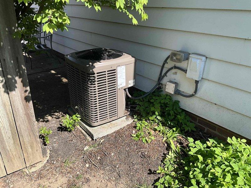 Performed comprehensive AC tune-up on residential split system with outdoor condensing unit and indoor air handler. System evaluated and found operating within normal parameters at time of service. Documented equipment condition through photographic inspection of outdoor unit installation on concrete pad with proper clearances and indoor mechanical components in basement utility area.
