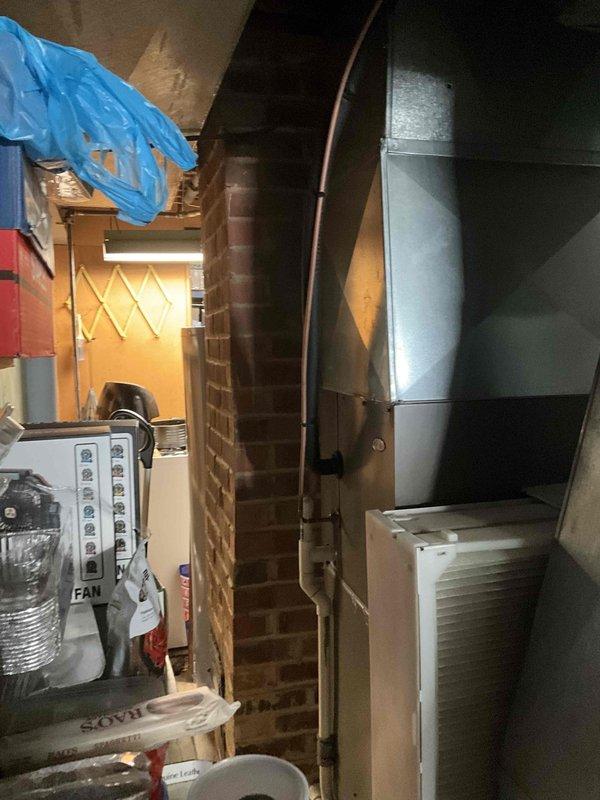 Performed comprehensive AC tune-up on residential split system with outdoor condensing unit and indoor air handler. System evaluated and found operating within normal parameters at time of service. Documented equipment condition through photographic inspection of outdoor unit installation on concrete pad with proper clearances and indoor mechanical components in basement utility area.