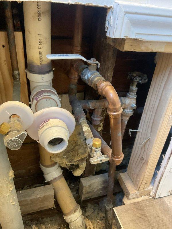 Responded to emergency water leak at 31-year-old residential property where homeowner reported significant water accumulation described as a "small lake." Upon arrival, accessed crawl space and identified active leak in aging copper plumbing system showing extensive corrosion and oxidation throughout multiple pipe sections and fittings. Located source of leak at deteriorated connection point where corroded copper piping met PVC drainage assembly near floor joists. 

Shut off water supply using existing valve system and assessed full extent of damage to plumbing infrastructure. Multiple sections of copper piping displayed advanced patina, surface oxidation, and compromised integrity due to age of installation. Replaced failed section of copper pipe and corroded fittings with new materials, ensuring proper connections between existing copper lines and PVC drainage system. Applied appropriate primer and secured all joints to prevent future leakage. Tested system under pressure to verify r
