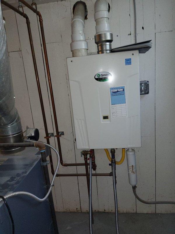 Completed routine home plan plumbing inspection of A.O. Smith tankless water heater installation in basement utility area. Verified proper operation of unit, inspected gas line connections, water supply lines, exhaust/intake PVC venting system, and confirmed all components meeting manufacturer specifications and safety standards. All systems functioning correctly with no issues identified during this recurring maintenance visit.
