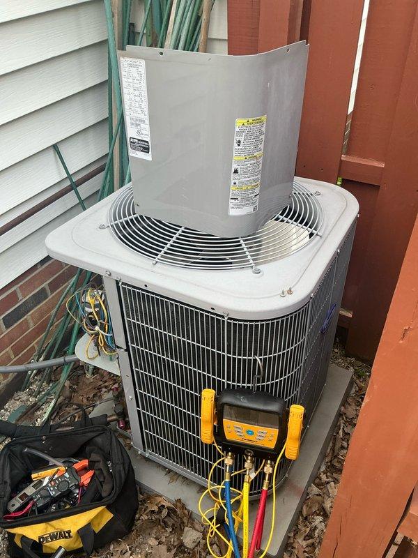 Performed comprehensive preemptive air conditioning tune-up and maintenance on outdoor condensing unit during off-season winter period. Connected digital manifold gauges to service ports and recorded system pressures and temperatures, with high-side pressure reading 245.9 psig and multiple temperature measurements including 117.8°F and 84.7°F to establish baseline performance metrics. Completed full preventive maintenance inspection of unit located in confined space between building and fence line, ensuring system readiness for upcoming cooling season.