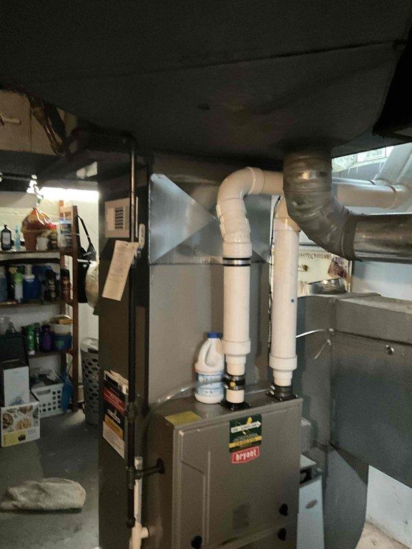 Conducted comprehensive evaluation of 6-year-old HVAC system experiencing ice damage to air handler unit. Assessed extent of damage to evaporator coil, refrigerant lines, and associated components in basement mechanical room. Documented current equipment condition including furnace, air handler with PVC condensate drainage system, and ductwork configuration. Photographed installation showing gray metal ductwork, white PVC venting, and existing system layout for estimate preparation. Provided detailed analysis comparing repair costs versus full system replacement options, taking into account age of equipment, severity of ice damage, and long-term reliability considerations. Recommended replacement due to extent of damage and equipment age approaching mid-life point where major component failures become increasingly common.