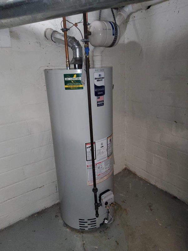 Completed full-day water heater replacement and repiping project in residential basement utility area. Removed existing water heater and installed new 50-gallon tall residential gas-fired unit with proper venting configuration. Replaced exposed CPVC water distribution lines with new white PEX piping throughout the service area, connecting to existing CPVC risers using SharkBite push-to-connect fittings for secure transitions. Installed pressure regulator at water meter to protect plumbing system and ensure proper operating pressure. All pipe connections tested and verified leak-free. Installation completed to code with proper support and routing of supply lines along ceiling joists. System commissioned and operational upon completion.