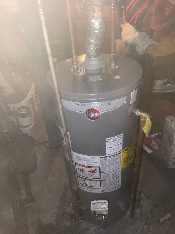 Responded to no hot water complaint on Rheem Performance tanked water heater. Upon arrival, conducted visual inspection of unit and surrounding area. Noted water staining on concrete floor around base of tank indicating possible leak or discharge from temperature and pressure relief valve. Inspected top connections including copper supply lines, pressure relief valve with discharge tube, and exhaust venting.

Removed access cover to inspect internal tank condition. Found significant sediment accumulation on tank floor consisting of mineral deposits, indicating extended period without maintenance flushing. Examined anode rod port, flue baffle assembly, and dip tube connection. Central flue pipe showed discoloration and wear consistent with combustion byproduct exposure. Mineral buildup was restricting proper water circulation and likely contributing to heating inefficiency and premature element or burner failure.

Documented existing conditions with photographs showing external unit con