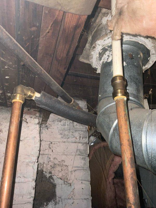 Responded to service call for leaking tanked water heater in basement utility area. Upon inspection, assessed the existing water heater installation including copper supply lines, brass compression fittings, and connection points for signs of active leakage and deterioration. Examined the tank unit, plumbing connections, temperature and pressure relief valve, and surrounding pipe infrastructure to determine source of leak and evaluate overall system condition. Documented existing conditions with photographs showing aged copper piping with natural patina, galvanized fittings, and deteriorated basement environment. Provided customer with assessment findings and presented options for both repair solutions and full water heater replacement based on the severity of the leak and age of the existing equipment.