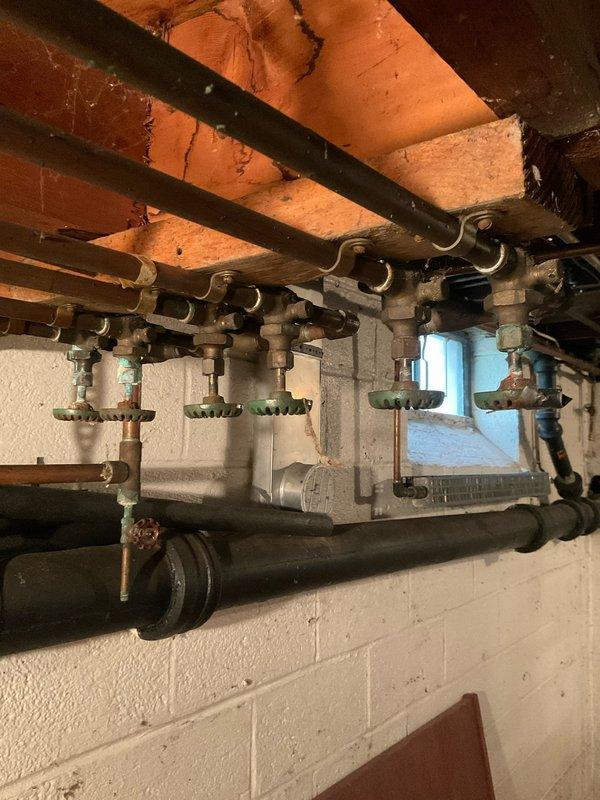 Completed comprehensive plumbing assessment as part of recurring home maintenance plan. Inspected basement plumbing infrastructure including manifold system with multiple zone valves, horizontal pipe runs with proper support hangers, water meter assembly with shut-off valves, and vertical PVC drain/vent stack. All components photographed and found to be in serviceable condition with no immediate repairs required.