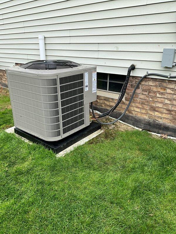 Completed full HVAC system replacement including installation of new two-stage high-efficiency furnace elevated on platform box and two-stage air conditioner with outdoor condenser unit mounted on rubber pad. Installed new AprilAire 4-inch media filter (20x25x4), ran refrigerant lines through foundation, mounted electrical disconnect box, routed PVC condensate drain line along exterior wall, and installed new programmable digital thermostat.