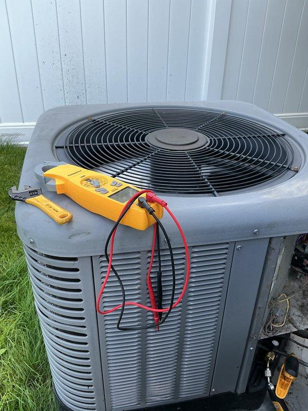 Performed comprehensive tune-up service on a 10-year-old Rheem outdoor condensing unit (Model RA1330AJ1RA, manufactured 05/2015) that had never received prior maintenance and was producing unusual operational noise. Conducted full system diagnostics using digital multimeter to verify electrical performance, including voltage readings, amperage draw, and contactor operation. Inspected condenser coil condition, fan motor operation, and compressor functionality. Unit showed signs of extended outdoor exposure with dirt accumulation and minor surface corrosion on cabinet panels. Verified proper refrigerant pressures and system cycling. Cleaned condenser coil of debris and contamination to restore optimal airflow and heat transfer efficiency. Checked all electrical connections at single pole contactors per manufacturer specifications. Lubricated fan motor bearings and tightened mounting hardware to eliminate noise source. System restored to proper operating condition with improved performanc
