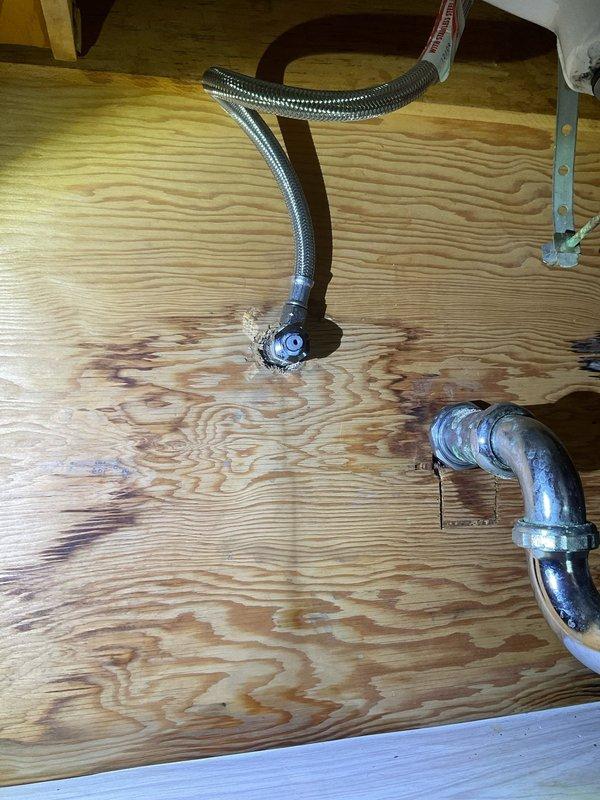 Responded to emergency plumbing call for multiple failed shutoff valves in 1955-era home. Upon arrival, assessed three compression-type shutoff valves with active leaks: one serving downstairs toilet, one at bathroom sink supply line, and one completely broken off at the supply line connection. Previous attempted repairs by occupant had exacerbated damage to valve stems and compression fittings. 

Shut off main water supply to prevent further water intrusion. Documented extensive water damage to subfloor plywood beneath fixtures, showing significant staining and moisture penetration. Removed all three failed compression valves and assessed supply line conditions. The valve that had broken off required additional attention to remove remaining components from the supply line without damaging copper piping.

Installed three new quarter-turn ball valves with appropriate compression fittings to replace failed units. Verified proper shutoff function on all new valves. Restored water supply a