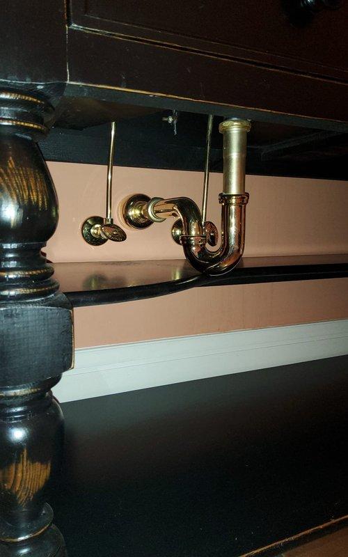 Responded to service call for hot water tank leak inspection and blank thermostat issue. Upon arrival, conducted thorough assessment of plumbing system beneath bathroom vanity, inspecting P-trap assembly and supply lines for signs of moisture or active leaking. Examined HVAC equipment in mechanical room, including light blue condensate pump unit mounted on support brackets with associated drainage hoses and ductwork connections. Verified thermostat functionality and power supply to heating system. Documented existing conditions with photographs for customer records and further evaluation of potential water heater concerns.