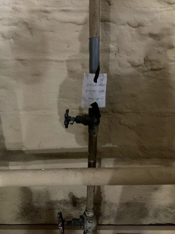 Responded to service call for low water pressure throughout residence and multiple dripping faucets. Performed diagnostic inspection of main water supply system, locating and documenting the main water valve in the utility area. Assessed plumbing infrastructure including supply lines and shut-off valves to identify potential causes of reduced pressure. Photographed valve location and piping configuration for service records and future reference.