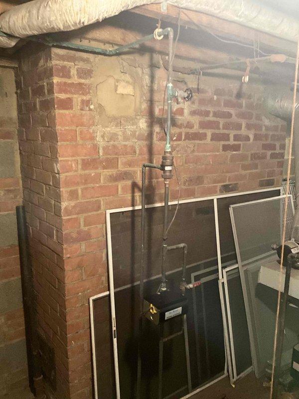 Conducted on-site boiler replacement estimate in residential basement mechanical room. Assessed existing conditions including aged brick walls with deteriorated mortar, current water heating equipment with copper and PVC piping connections, and overhead ductwork with insulation. Evaluated confined workspace limitations, existing plumbing infrastructure, and necessary access points for equipment removal and installation. Documented mechanical room layout, pipe routing configurations, and structural considerations for new boiler system installation planning.
