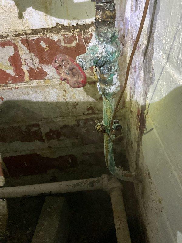 Responded to callback for water heater installation with reported basement water leakage. Upon inspection, confirmed system was operating at approximately 60 PSI without proper pressure regulation. Identified missing pressure reducing valve and thermal expansion tank from original installation, both critical components for safe water heater operation and code compliance. Documented existing corroded plumbing infrastructure and deteriorated pressure relief valve assembly showing significant oxidation and mineral buildup. Photographed current system configuration including pressure gauge readings and condition of existing brass fittings and copper piping. Explained to customer the necessity of installing pressure regulator to protect water heater from excessive incoming water pressure and expansion tank to accommodate thermal expansion, preventing potential system failure and water damage. Recommended immediate installation of both components to bring system into compliance and resolve l