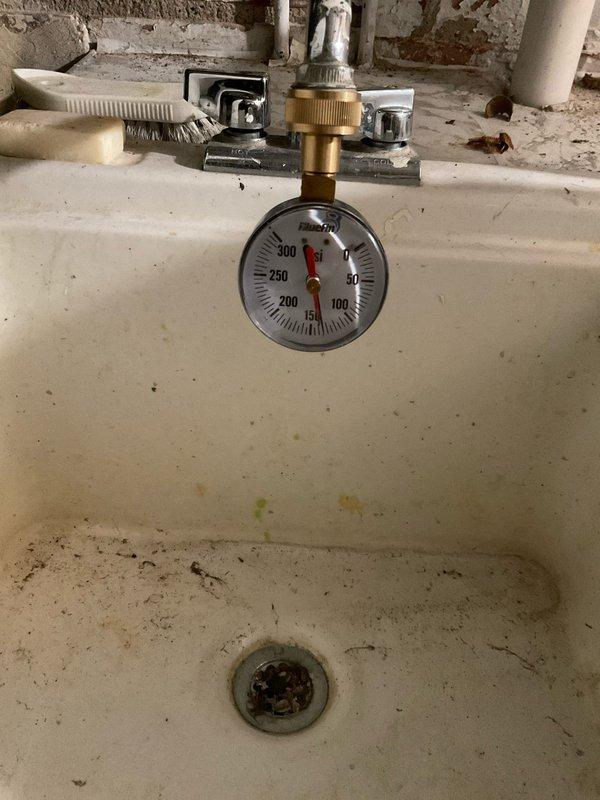 Responded to a water heater leak originating from the outlet connection on a previously installed tanked unit. Upon arrival, identified active water discharge from the hot water outlet fitting causing floor saturation in the installation area. Performed pressure testing using diagnostic gauge to verify system pressure and identify the source of the leak at the outlet connection. Addressed the faulty outlet fitting, secured all connections, and verified proper seal integrity. Cleaned up standing water from the concrete floor surface surrounding the unit. Conducted final pressure test to confirm leak resolution and proper system operation before restoring unit to service.