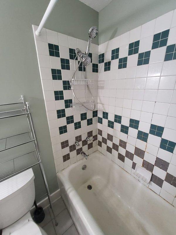 Installed customer-supplied Moen shower valve and EVA trim kit with separate hot and cold water handles in bathroom tub/shower combination. Work required wall access to install new valve body and plumbing connections, with trim kit mounted to finished tile surface featuring decorative white, teal, and brown pattern. Installation completed per customer specification to maintain separate handle operation rather than single-handle configuration.