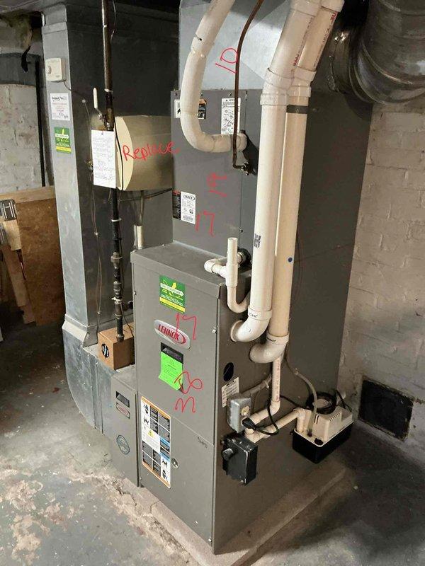 Responded to no-heat service call for non-operational furnace in basement. Upon inspection, confirmed existing Lennox furnace unit was not turning on and determined equipment had reached end of service life based on age and condition. Marked unit for replacement and documented existing installation configuration including white PVC condensate piping, copper refrigerant lines, electrical panel connections, and metal ductwork connections. Photographed current system layout showing furnace positioning, venting arrangement, drainage setup with black condensate pump, and electrical service panel for reference during replacement planning. Provided estimate for complete furnace replacement to restore heating functionality to residence.