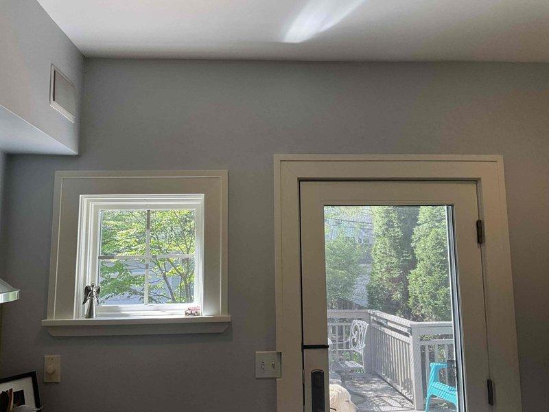 Conducted on-site assessment for mini split installation in residential property. Evaluated two potential installation locations: bedroom area with existing window configuration and adjacent room with glass door access to exterior deck. Documented existing electrical infrastructure, wall conditions, and outdoor mounting options for condenser unit placement. Photographed interior spaces to determine optimal indoor head unit positioning and exterior access points for refrigerant line routing.