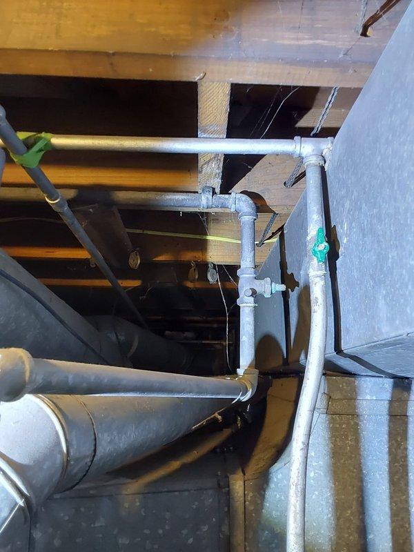 Responded to emergency water leak in basement of 96-year-old residential property where hot water tank was actively flooding the area. Upon arrival, assessed the compromised water heater and associated plumbing connections, including overhead piping infrastructure with PVC and gas lines running through exposed floor joists. Addressed the Lochinvar brand water heater failure, secured the water supply, and mitigated the active flooding condition to prevent further property damage to the basement structure and stored contents.