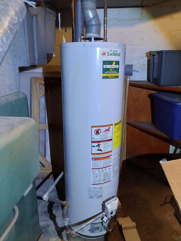 Responded to emergency water leak in basement of 96-year-old residential property where hot water tank was actively flooding the area. Upon arrival, assessed the compromised water heater and associated plumbing connections, including overhead piping infrastructure with PVC and gas lines running through exposed floor joists. Addressed the Lochinvar brand water heater failure, secured the water supply, and mitigated the active flooding condition to prevent further property damage to the basement structure and stored contents.