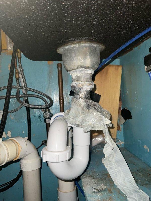 Responded to service call for slow drainage issues affecting kitchen faucet, bathroom sink, and tub drain in a 1930s-era home. Assessed existing plumbing system and identified drainage concerns related to aging infrastructure. Removed old kitchen faucet and installed customer-provided replacement unit, ensuring proper mounting and connection to existing supply lines. Addressed slow drainage problems in multiple fixtures by clearing obstructions and evaluating the condition of vintage drain assemblies and P-trap configurations. Inspected under-sink plumbing, noting deteriorated components and aging PVC trap assembly with visible wear. Restored proper water flow and drainage function to all affected fixtures. Tested new faucet installation for leaks and verified adequate water pressure and drainage performance throughout the system.