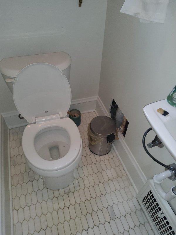 Responded to emergency plumbing issue in second-floor full bathroom where improper drainage installation caused significant water accumulation in ceiling below. Identified double-trapped 1.5-inch PVC drain line connected to bathtub with improperly installed air admittance valve left open, creating drainage failure. Created access opening in ceiling below bathroom to expose and assess tub drain, lavatory drain, and toilet drainage systems. Recommended complete re-piping of all bathroom drainage fixtures to correct code violations and prevent further water damage.