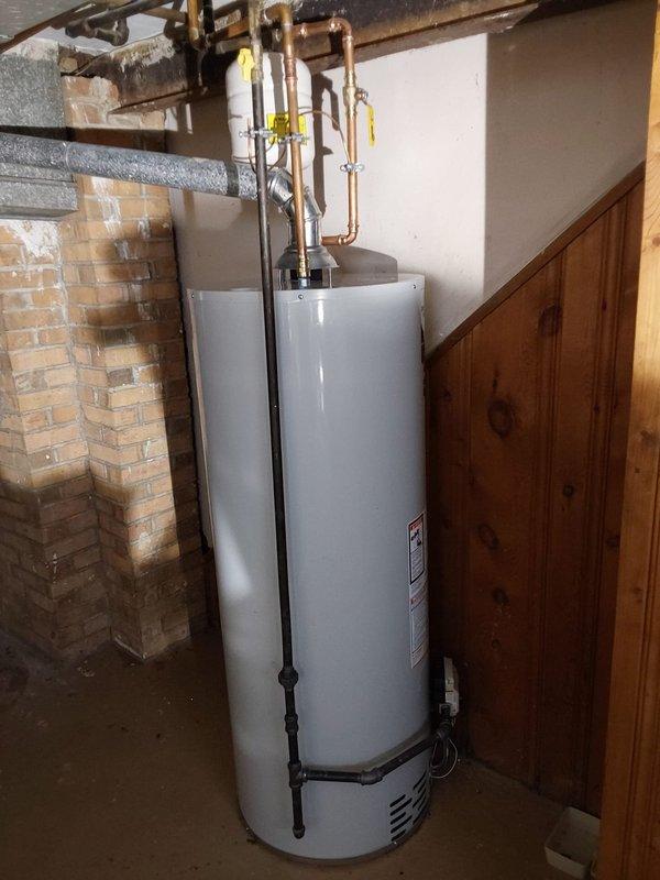 Conducted free estimate for water heater replacement in basement. Evaluated existing 13-year-old tank-style water heater showing signs of age, documented current installation including gas valve assembly, piping connections, and venting configuration. Photographed unit specifications, manufacturer labels, and existing plumbing setup to provide accurate replacement recommendations.