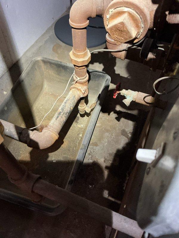 # HVAC Service - Boiler

Responded to service call for boiler leaking hot water from bottom, upper left-hand corner. Upon arrival, parked in back of driveway per customer request and proceeded to inspect the unit. Investigation revealed active water leakage originating from the lower section of the boiler assembly. Documented conditions with photographs showing water accumulation on basement floor with visible staining and moisture damage to surrounding concrete surfaces. The leak source was traced to the upper left-hand corner area of the boiler's lower section, indicating potential failure of internal components, gaskets, or tank integrity. Photographed evidence of water intrusion and assessed the extent of damage to the installation area. Customer was advised of findings and provided recommendations for repair or replacement options based on the age and condition of the unit.