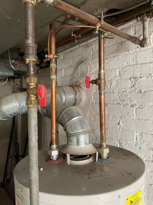 Replaced primary and secondary washer shut-off valves in basement utility area. Installed new copper piping with brass fittings and red-handled manual control valves to provide reliable water flow control to washing machine connections. Work completed as part of coordinated multi-visit repair schedule requiring city clearance approval, with all new plumbing components properly secured and tested for proper operation.