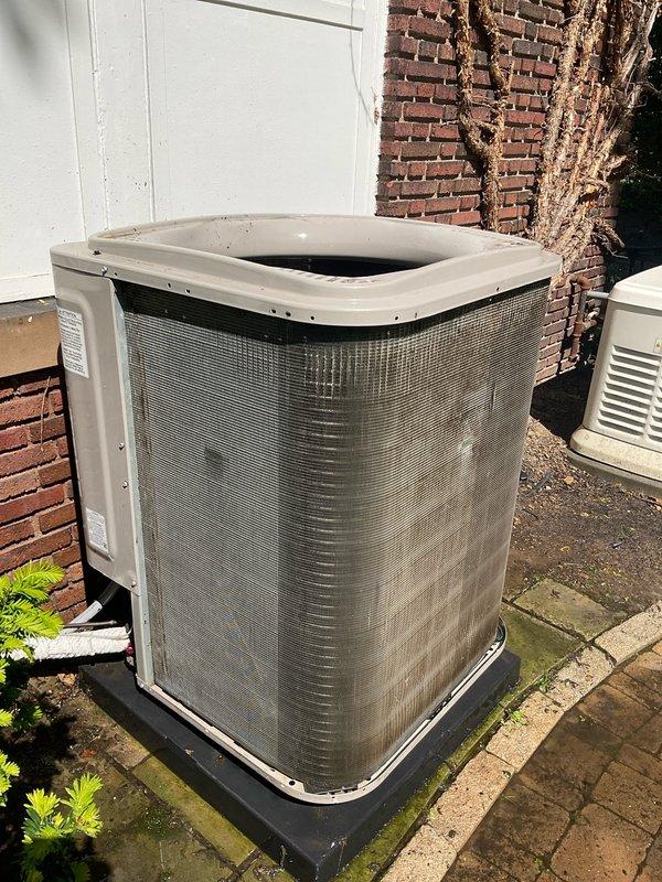 Performed complete condenser cleaning service on outdoor AC unit. Unit was accessed at exterior location against brick wall, where significant debris accumulation was found affecting system performance. Thoroughly cleaned condenser coils, removed dirt and organic matter from unit exterior and surrounding area. Inspected all accessible components during cleaning process. No replacement parts were required to complete this maintenance service. Customer was advised scheduling took approximately two hours and was informed service would be completed after 10 AM. Unit operational and ready for continued service upon completion.