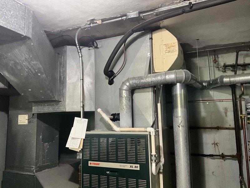 Conducted comprehensive estimate for complete HVAC system replacement including gas furnace and air conditioning unit. Evaluated existing Trane XL 80 furnace installation, associated ductwork infrastructure, refrigerant line routing along exterior foundation, and condensate drainage system. Documented current equipment configuration, outdoor condenser location adjacent to foundation landscaping, and mechanical room layout to provide accurate replacement specifications and installation requirements.