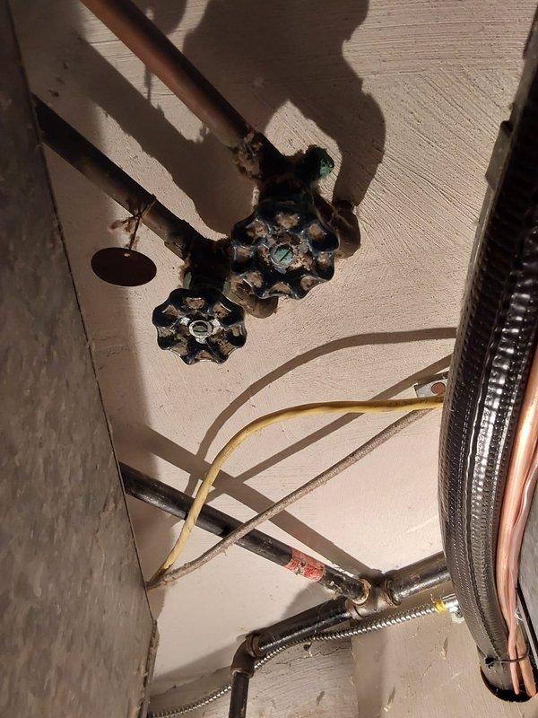 Completed comprehensive plumbing assessment for tankless water heater conversion feasibility in residential utility space. Evaluated existing plumbing infrastructure including copper manifold system with multiple branch lines, shut-off valves, and distribution piping, as well as current water heater connections featuring aged gate valves and flexible supply lines. Documented electrical panel capacity concerns and provided recommendations for panel upgrade options if required to support tankless unit installation.