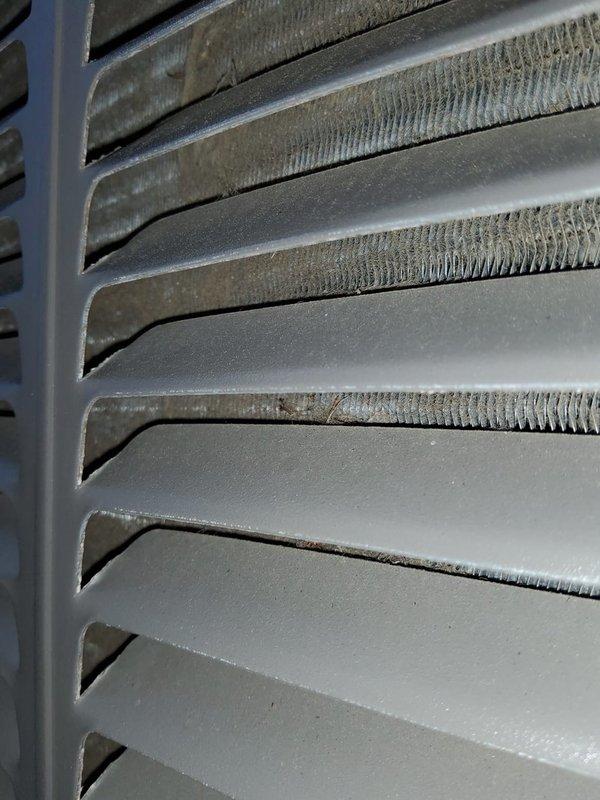 Completed scheduled cooling system tune-up and preventive maintenance inspection. Examined outdoor condenser unit coil assembly, noting moderate dust and debris accumulation on aluminum heat exchanger fins affecting airflow efficiency. Documented current condition of finned coil surfaces showing typical operational wear and environmental exposure consistent with regular system use.