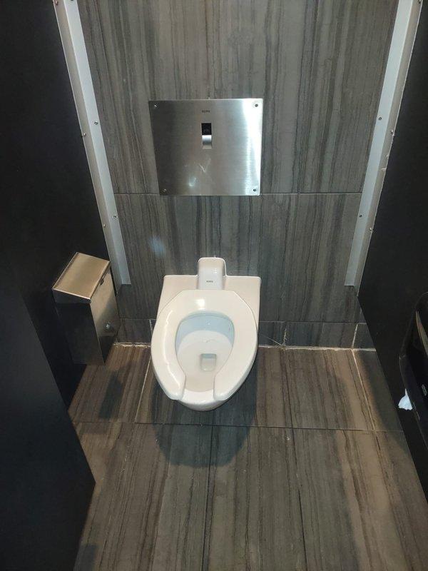 Completed toilet repair service requiring two technicians over a six-hour period in a commercial bathroom facility. Accessed and serviced wall-mounted TOTO toilet system through existing access panel, addressing plumbing valve assembly and associated electrical connections. All fixtures restored to proper working order, access panel secured, and area left clean and operational.