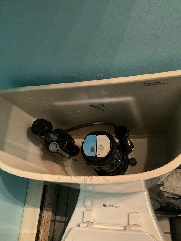 Inspected toilet tank and shower valve assembly to provide repair estimates. Evaluated Glacier Bay toilet internal flushing mechanism, including black plastic float assembly, flapper seal, and fill valve for proper operation and potential replacement needs. Assessed Delta Monitor single-handle shower mixing valve with chrome trim plate and control handle for functionality and repair requirements. Documented existing conditions including minor water staining and mineral deposits in toilet tank, and typical wear patterns on shower valve components. All necessary replacement parts identified for future repair work.