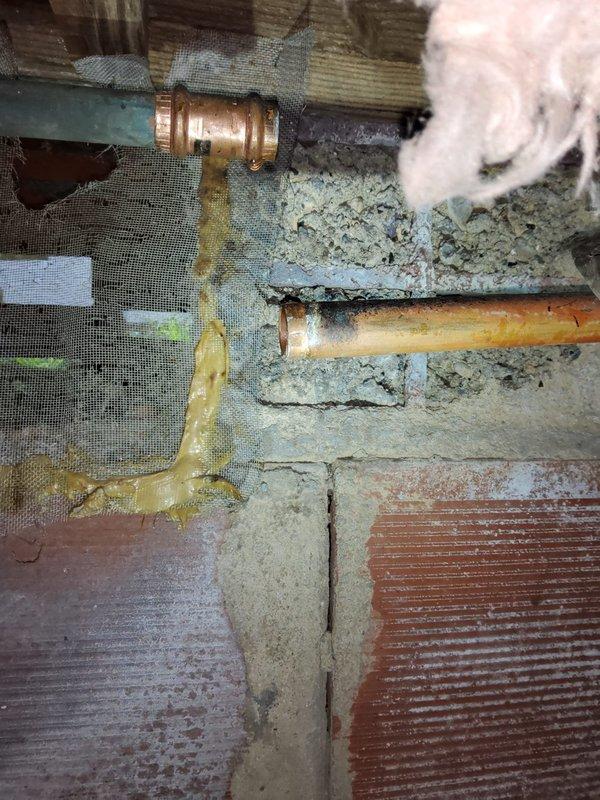 Responded to emergency call for frozen anti-frost spigot installed the previous year with suspected burst pipes. Upon arrival, inspected exterior spigot mounted on brick wall and accessed crawl space to evaluate copper supply line condition. Found compromised pipe insulation and deteriorated vapor barrier mesh in underfloor area. Assessed brass fittings and copper piping for freeze damage, verified structural integrity of plumbing connections, and documented conditions of both exterior spigot installation point and interior supply line routing through floor joists.