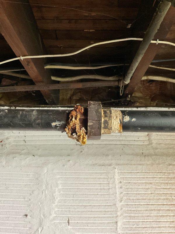 Responded to water leak in basement of 106-year-old residential property. Upon arrival, located source of leak in crawl space beneath main floor. Inspection revealed severely corroded galvanized steel supply piping with extensive rust deterioration at multiple joints and valve connections. Primary leak originated from compromised vertical pipe section where corrosion had penetrated through pipe wall at coupling assembly.

Shut off main water supply to prevent further water damage. Removed failed corroded pipe section and associated fittings exhibiting structural compromise from rust buildup and mineral deposits. Cut out approximately four feet of deteriorated galvanized piping. Installed new copper pipe section with compression fittings and brass shutoff valve to replace corroded assembly. Secured new piping to floor joists with appropriate hangers and supports.

Tested system for leaks by restoring water pressure and monitoring all connections for twenty minutes. Verified no active le
