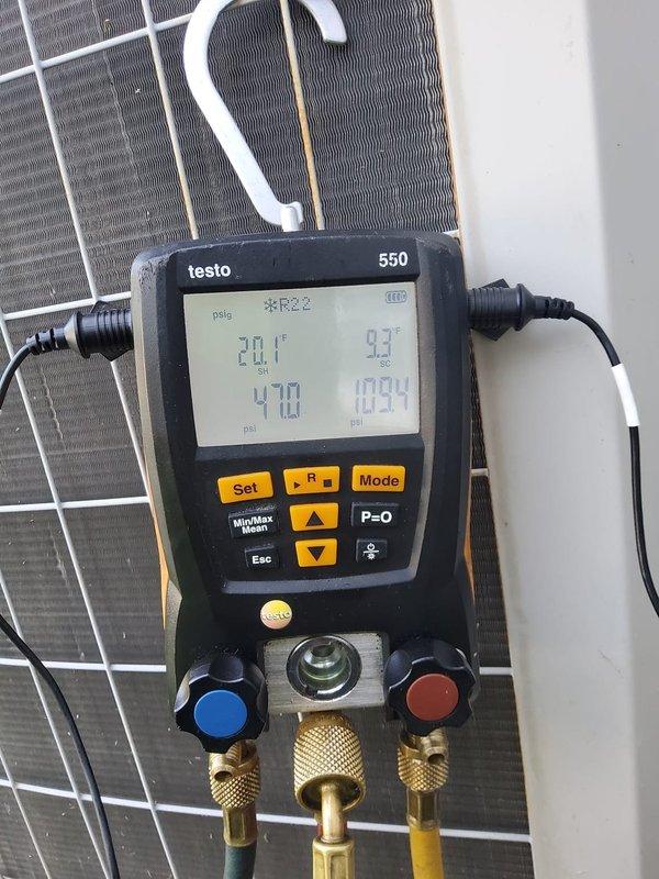 # HVAC Maintenance - Cooling System Service

Performed comprehensive preventive maintenance on a 15+ year old heat pump/air conditioning system utilizing R-22 refrigerant. This was the first service call for this MVP customer, conducted during the morning service window.

## Work Performed

Conducted complete system diagnostics using calibrated Testo 550 digital manifold gauge set to evaluate system performance and refrigerant charge. Connected gauges to service ports and recorded operating pressures and temperatures across the system. High-side pressure reading of 470 psig and low-side pressure of 109.4 psig were documented during operation. Temperature measurements showed 43°F on the suction line and 54°F at the liquid line, with ambient conditions at 28.1°F indicated on the instrument display.

Performed visual inspection of outdoor condenser unit, examining coil condition, electrical connections, and overall system integrity. Assessed the heat exchanger fins and condenser coil for 